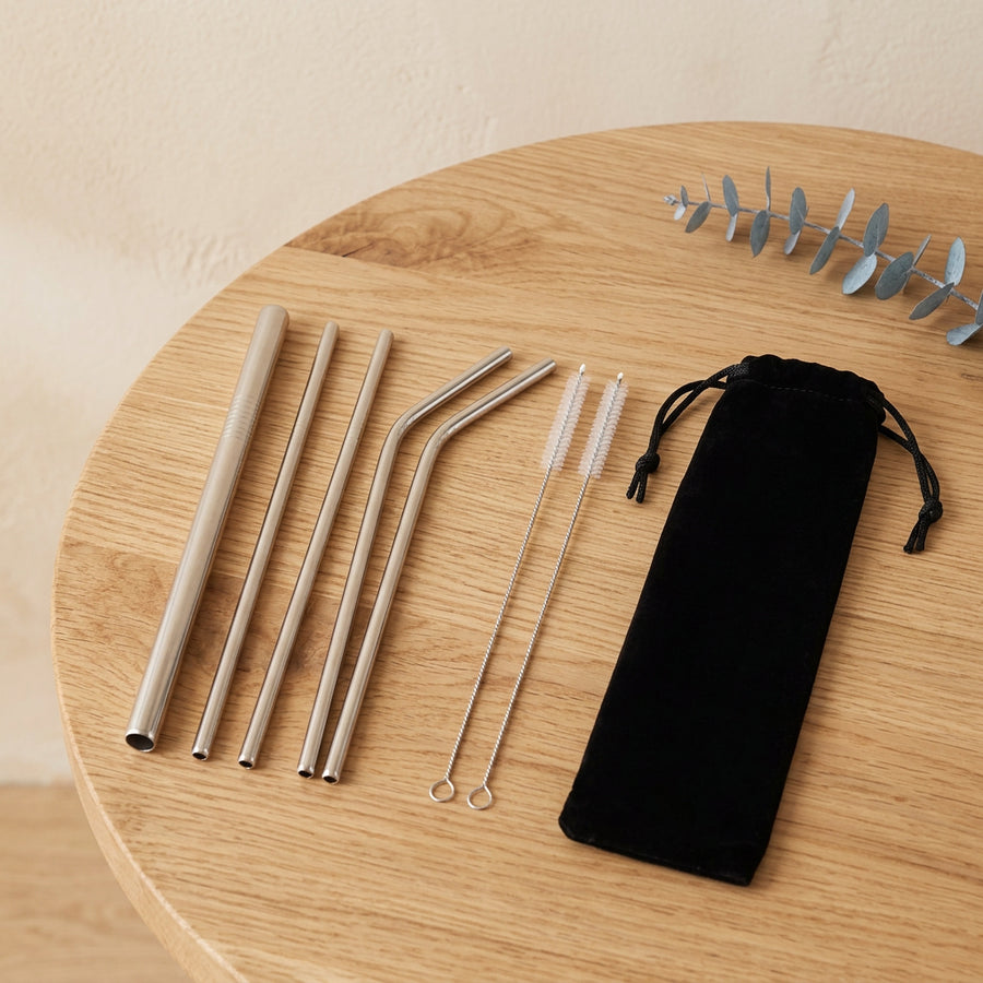 Pailles en inox avec pochette et brosses sur fond crème